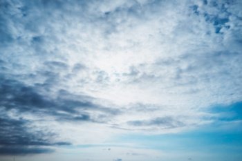 Beautiful blurry sky backdrop. Abstract natural background. Fluffy white clouds on the overcast sky. Autumn season nature.. Beautiful blur dreamy sky background