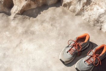 Sport shoes on stone rocks. Mountain active vacation background concept. Created with generative Ai technology.