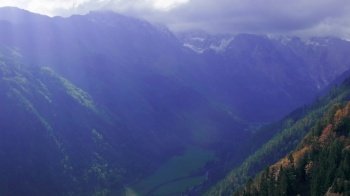 Logar Valley sun rays. View on cloudy October mountain valley from above. Logarska Dolina, Slovenia. Handheld pan. Logar Valley, Slovenia