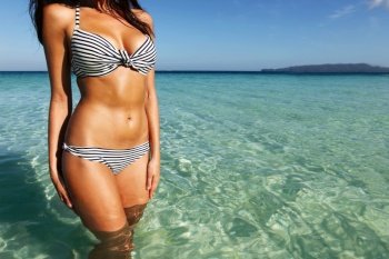 Beautiful young woman in bikini posing in sea . Woman in bikini in sea