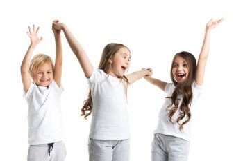 Happy smiling three children in white clothes holding raised hands isolated on white background. Happy children isolated on white