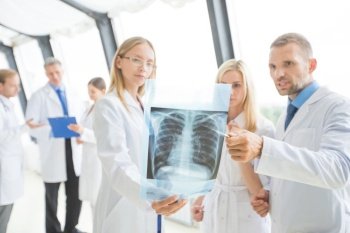 Group of doctors look and discuss x-ray in a clinic or hospital. Group of doctors discuss x-ray