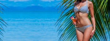 Beautiful woman with cocktail posing on tropical beach. Woman with cocktail on beach