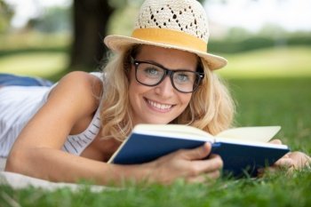 happy woman enjoys reading a book in the garden