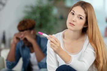 sad girl holding a pregnancy tester