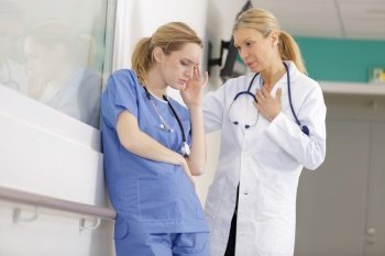 colleague helping nurse suffering from stress
