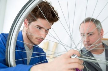 portrait of an apprentice fixing a wheel