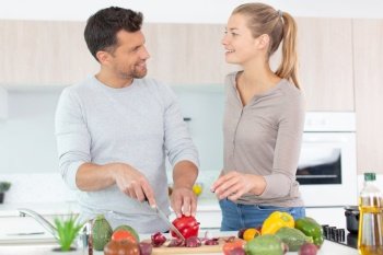 portrait of young couple cooking together healthy vegetarian dish