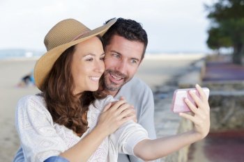 young happy couple making a selfie on beach
