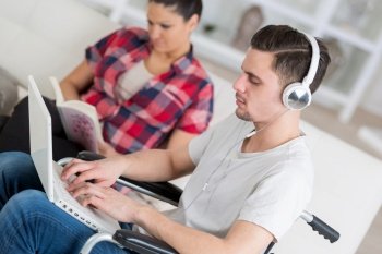disabled man using laptop sitting next to his girlfriend