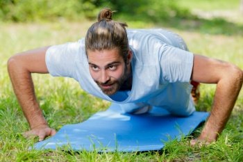 man doing push up on yoga mat outdoor