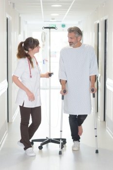 patient using cane while looking at female doctor