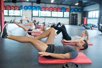 group of people training legs in a gym
