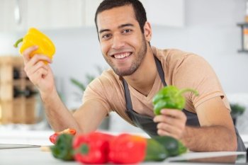 portrait of positive cheerful man enjoying cooking