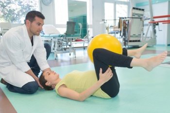 pregnant woman exercising with physiotherapist in birthing school