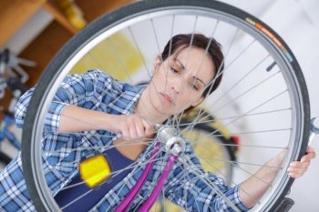 young woman repairing her bicycle