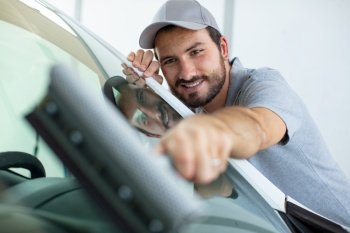 specialist fixing crack on car windshield in repair shop
