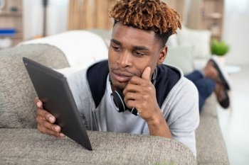 guy enjoying music using digital computer tablet at home