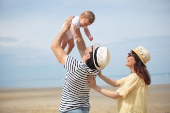 parents and baby on the beach