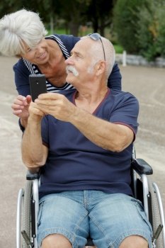 senior couple in wheelchair taking selfies