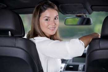 young and beautiful woman looking back inside of a car