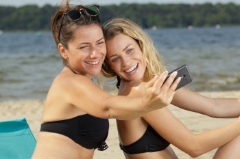 two young female friends doing a selfie on the beach