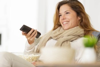 woman with remote control from the tv and popcorn