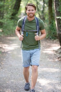 male hiker walking in forest outdoors in nature