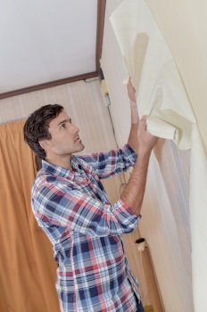 male worker removing old wallpaper