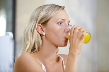 woman drinking orange flavored drink or juice