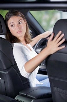young woman driver turning back