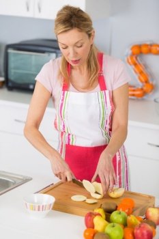 woman holding knife and cutting fruit in kitchen