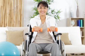 woman on wheelchair holding weights