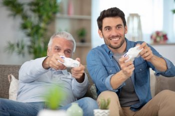 portrait of two excited men playing video game at home