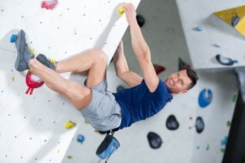 strontg climber hanging on a wall and smiling