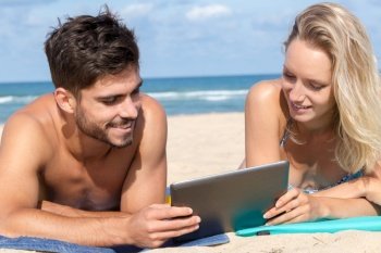 couple on beach using tablet