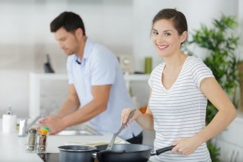 young housewife steering frying pan