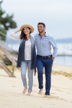 couple walking through sand dunes together