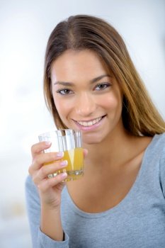young beautiful woman in kitchen drinking juice