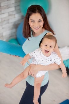 mother with the baby in her arms in the gym