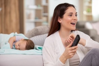 mother watches tv while her baby sleeps