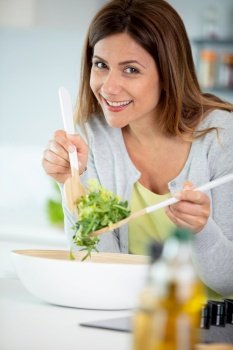cheerful woman tossing a salad