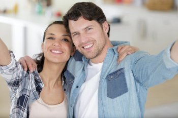 young couple in love making a funny selfie at home