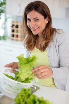 woman washing lettuce leaves for a healthy salad