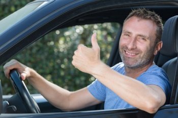 man in a car giving thumbs up