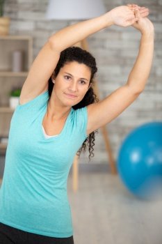 young woman smiling doing workout stretching her arms