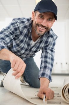 professional worker cutting laminate floor insulation