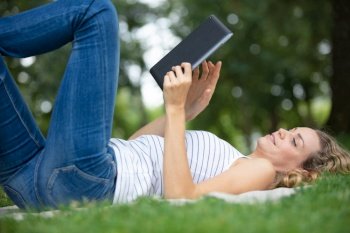 young woman reading book in the park