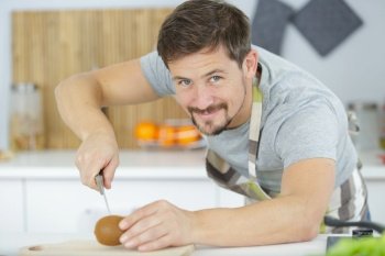 man cutting tomatoes on cutting board