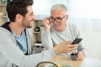 old father and son using phone